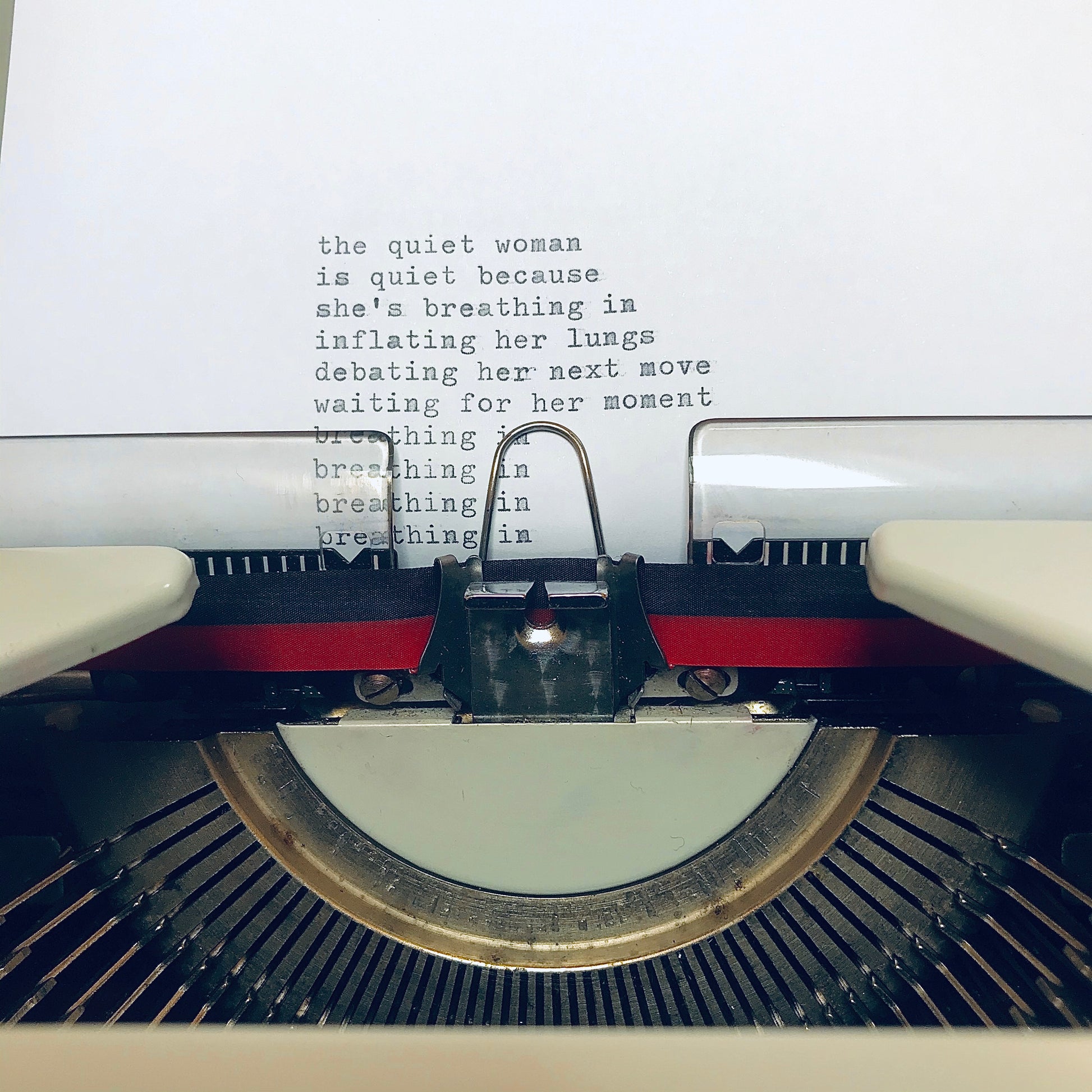 opening text of The Quiet Woman poem being typed on a typewriter